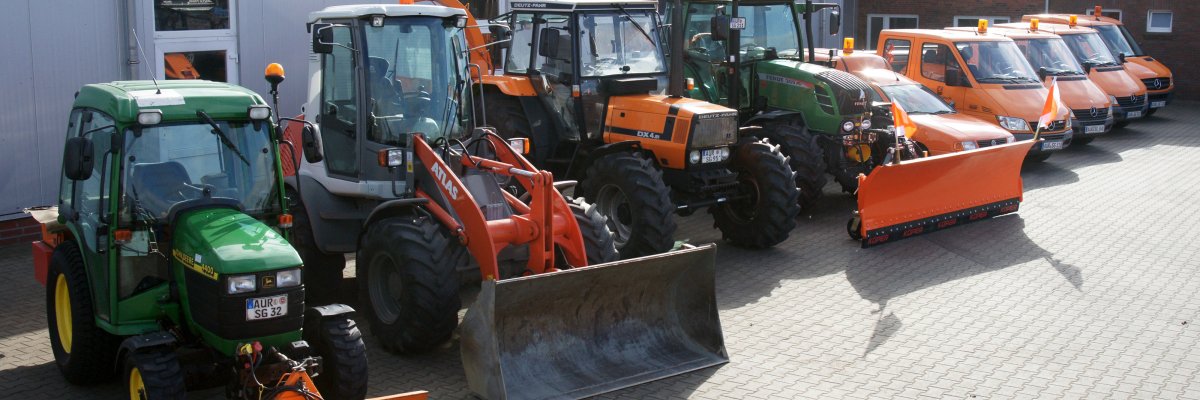 Bilder von der Samtgemeinde Hage  Auf dem Bild stehen Trecker sowie Bauhof Fahrzeuge vor eine Halle