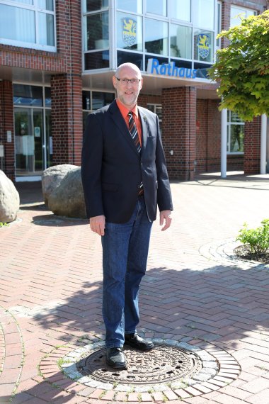 In diesem Bild sehen Sie den Samtgemeindebürgermeister Erwin Sell. Er steht vor dem Rathaus in Hage. 