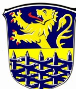 Wappen Flecken Hage In diesem Bild sehen Sie das Wappen der Gemeinde Flecken Hage. Der Hintergrund ist blau und gelb. Im Vordergrund ist ein blauer Zaun zu sehen. Hinter dem Zaun befindet sich ein gelber Löwe.