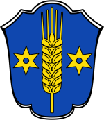 In diesem Bild sehen Sie das Wappen der Gemeinde Berumbur. Der Hintergrund ist blau. Auf dem Wappen befindet sich rechts und links jeweils ein Stern und in der Mitte eine Gerstenpflanze. 